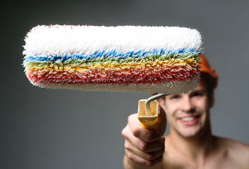 Man holds paint roller. Man worker in hard hat. Room painting job. Painter contractor in protective helmet. Man worker. Construction. Tool shop. Selective focus. Whitewasher. © Svitlana