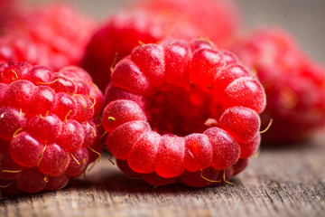 Ripe raspberry on the wooden bark. Selective focus. Shallow depth of field.