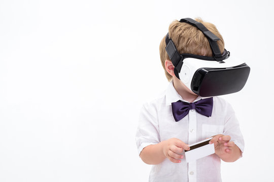 Boy with blank credit card. Credit card. Cash card. Business-card. Copy space for bank advertising. Plastic bank-card with magstripe. Virtual reality. Virtual reality glasses. Boy in VR headset.