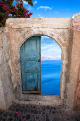 Eine alte Tür in Santorini mit einer schönen Ansicht  auf das Meer