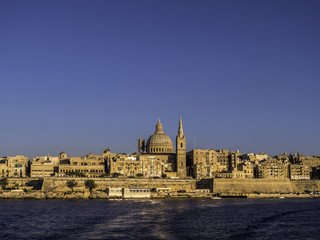 Fototapeta na wymiar Skyline of Valletta Old Town from the Harbour during sunset hour