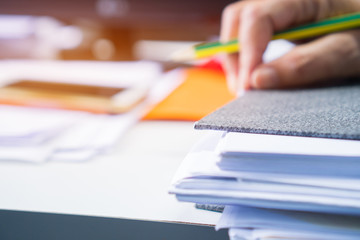 Document Report and business busy Concept: Asian Businessman hands working in many documents Stacks of folders in office for Annual Report files, Piles of unfinish sheet folder close annual budget.