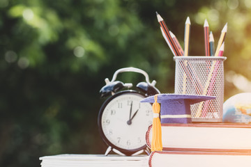 Graduate or Education knowledge study abroad concept : Graduation cap on textbook with pencil box...