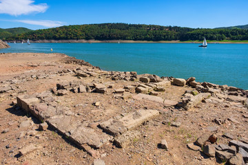 Der Edersee bei Niedrigwasser mit freigegebenen Grundmauern eines Gebäudes des Dorfes Berich