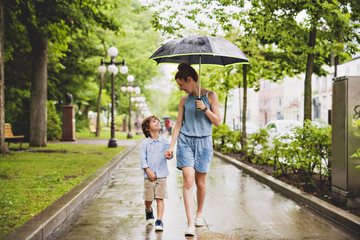 mother and child on a rainy day in a park with umbrella