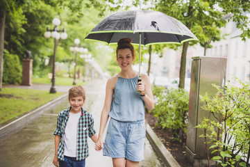 mother and child on a rainy day in a park with umbrella