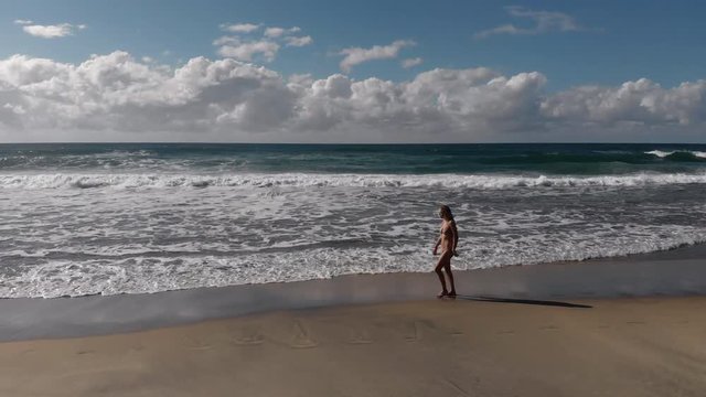 Woman Walking Along a Secluded Beach Alone