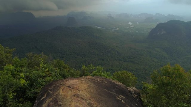 Walking on top of tab kak hang nak hill cliff with incredible view on beutiful landscape at krabi thailand - aerial drone shot