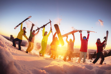 Happy friends at ski resort having fun sunset