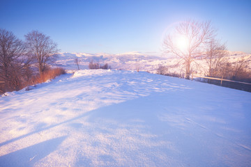 Fototapeta na wymiar Beautiful winter nature landscape, amazing mountain view of sunset. Scenic image of snowy woodland.