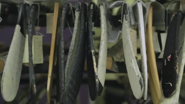 Rows of old hockey sticks stacked on top of each other.