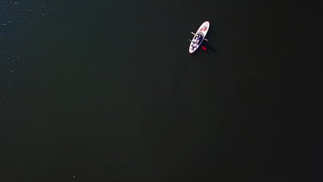Young girl sits on a kayak sailing along the river