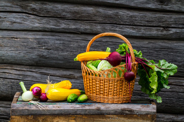 Fresh, bright, healthy vegetables in a basket on a wooden background. Harvesting vegetables