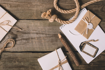 flat lay with blank textbook, wrapped letters, tree pencil and nautical rope on wooden background