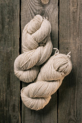 elevated view of two woolen beige knitting yarn balls on wooden background