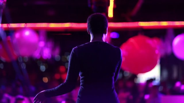 Singer on stage in a busy night club.