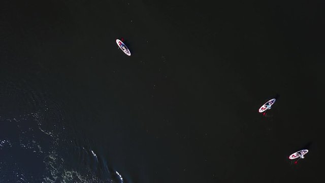 Three kayaks are sailing along the river