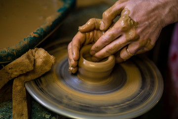 Sculpts in clay pot closeup. Modeling clay close-up. Caucasian man making vessel daytime of white clay in fast moving circle. Art, creativity. Ukraine, cultural traditions. Hobbies