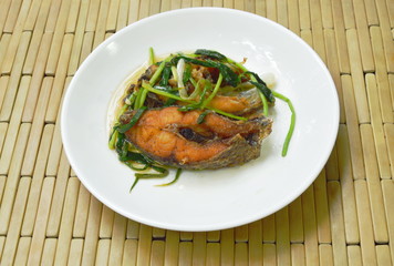deep fried Nile Tilapia or mango fish slice dressing soy sauce and spring onion on plate