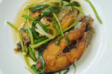 deep fried Nile Tilapia or mango fish slice dressing soy sauce and spring onion on plate