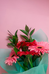 bouquet of pink and red gerberas on a pink pastel background