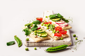 Healthy sandwiches with soft cheese and raw vegetables on crisp bread