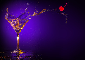 red cherry splashing out of a martini glass on a purple background