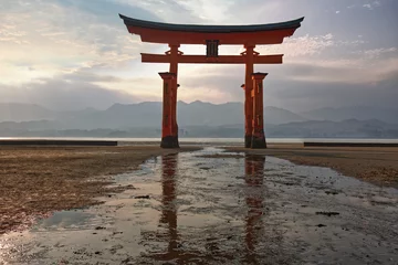 Fotobehang torii of Itsukushima shrine with low tide at sunset © Paulista