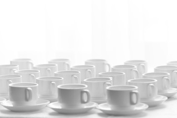 Top view on many stacked in rows of empty clean white cups for tea or coffee. Close-up. Background.