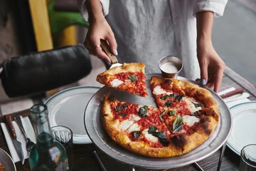 Fotobehang cropped shot of serving delicious pizza at restaurant © LIGHTFIELD STUDIOS