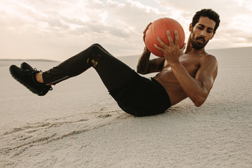 Fototapeta na wymiar Athlete doing medicine ball workout in desert
