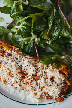 delicious lasagne with green leaves on rustic wooden teable
