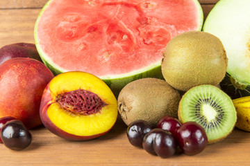 Still life with varied fruits on wooden background.