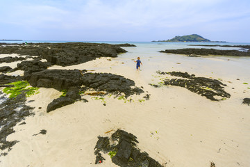 Fototapeta na wymiar A kid on a beach on a Jeju Island in Korea