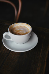 close-up shot of cup of delicious coffee on rustic wooden table at restaurant