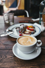 close-up shot of delicious syrniki on plate and cup of coffee on rustic wooden table