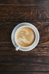 top view of cup of delicious coffee on rustic wooden table