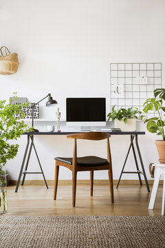 Antique Wooden Chair By A Desk With An Empty, Mock-up Computer Screen In A Stylish Home Office Interior For A Freelancer