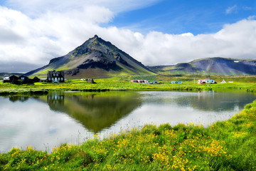 Beautiful fishing village view of Arnarstapi with water reflection of Mount Staoafell in the background at Snaefellsnes Peninsula, Iceland