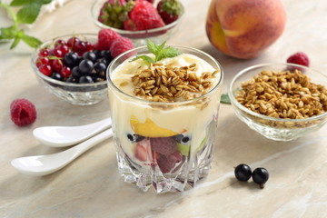 Dessert with fresh berries, granola and custard in glasses