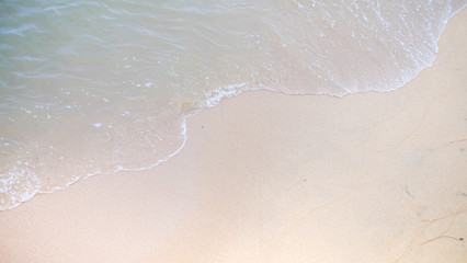 Soft wave of the ocean to the sandy beach view.