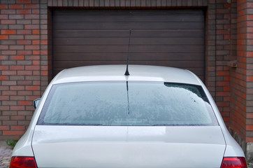 Part of a car parked in front of the garage door