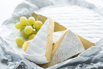 close up view of camembert cheese and grape