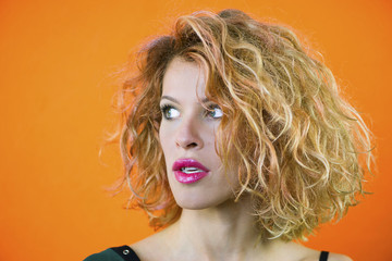 face of a pretty girl with curly hair and red lips closeup
