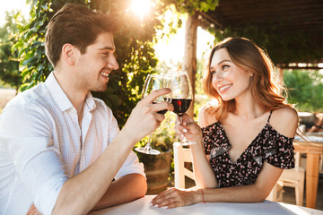 Loving couple sitting in cafe by dating drinking wine - Powered by Adobe