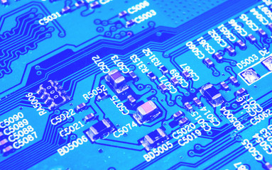 Macro shot of a Circuitboard with resistors microchips and electronic components. Computer hardware technology. Integrated communication processor in blue tones. Semiconductor. PCB. Closeup