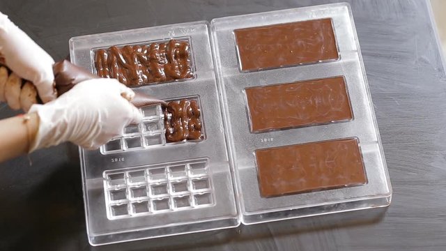 Preparation of dark chocolate bars made from scratch using cocoa butter and sugar.