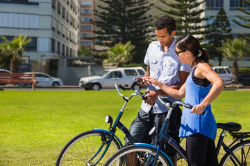 Young Couple on Bicycles Check Mobile Phone