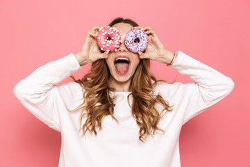 Portrait of a happy young woman showing donuts - obrazy, fototapety, plakaty