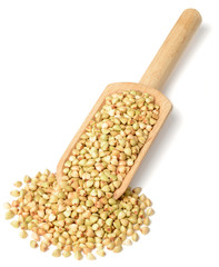 uncooked buckwheat in the wooden scoop, isolated on the white background, top view